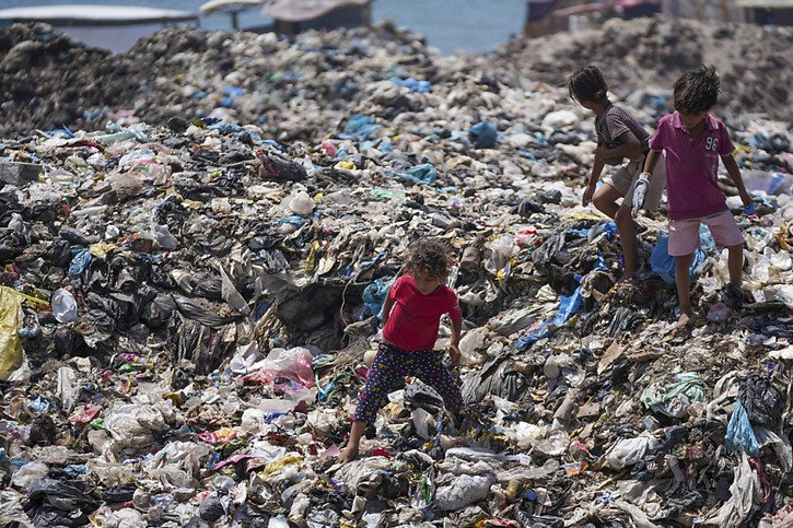 Des enfants palestiniens sur une montagne d'immondices dans le camp de réfugiés de Nuseirat. © KEYSTONE/AP/Abdel Kareem Hana