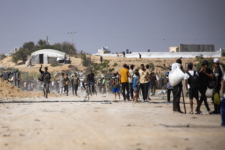 Des Palestiniens inspectent leurs tentes dans un camp de déplacés à l'ouest de la ville de Rafah, au sud de la bande de Gaza, après le retrait des véhicules de l'armée israélienne. © KEYSTONE/EPA/HAITHAM IMAD